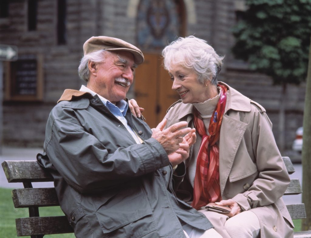 Old Couple sitting on bench enjoying their pension