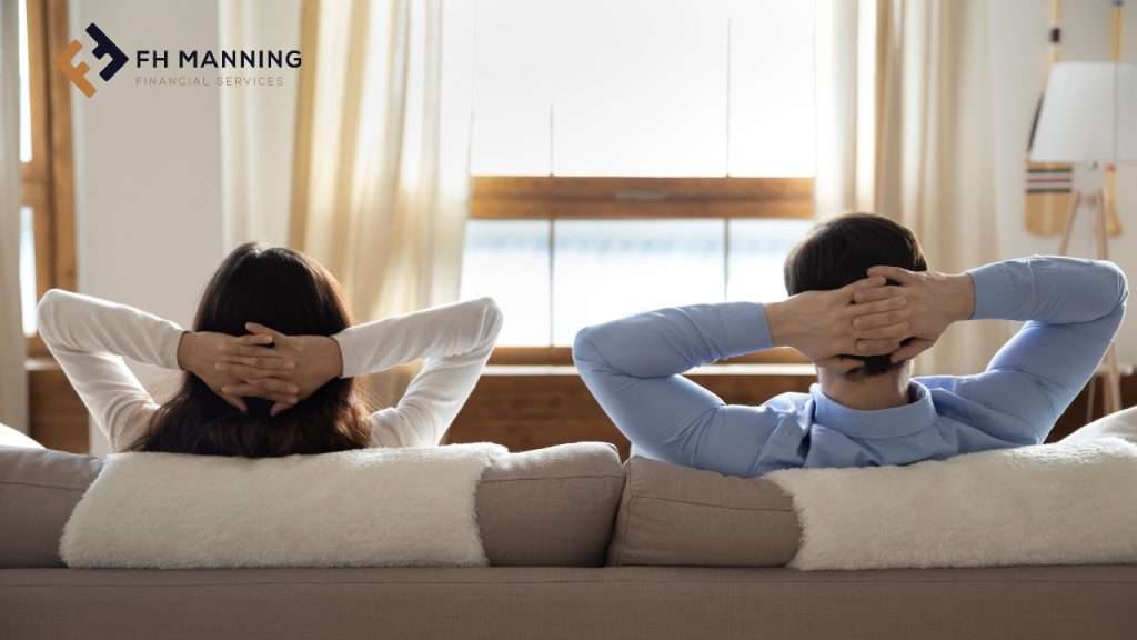 Man and woman on sofa with hands behind their heads